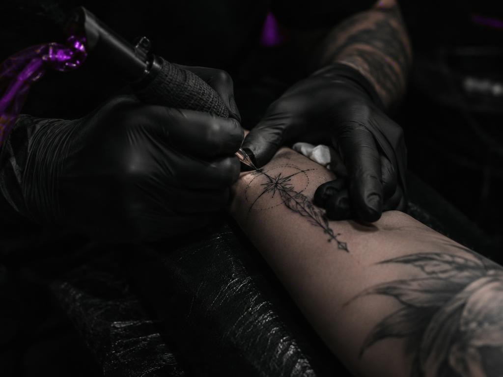 Artist tattooing a fine-line design
